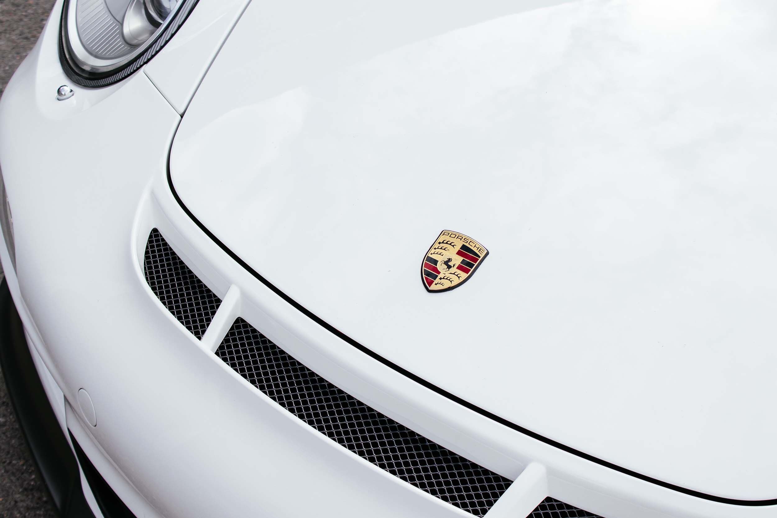 a close up of the hood of a white porsche 911 gt3. SCC Care available for premium and exclusive cars.