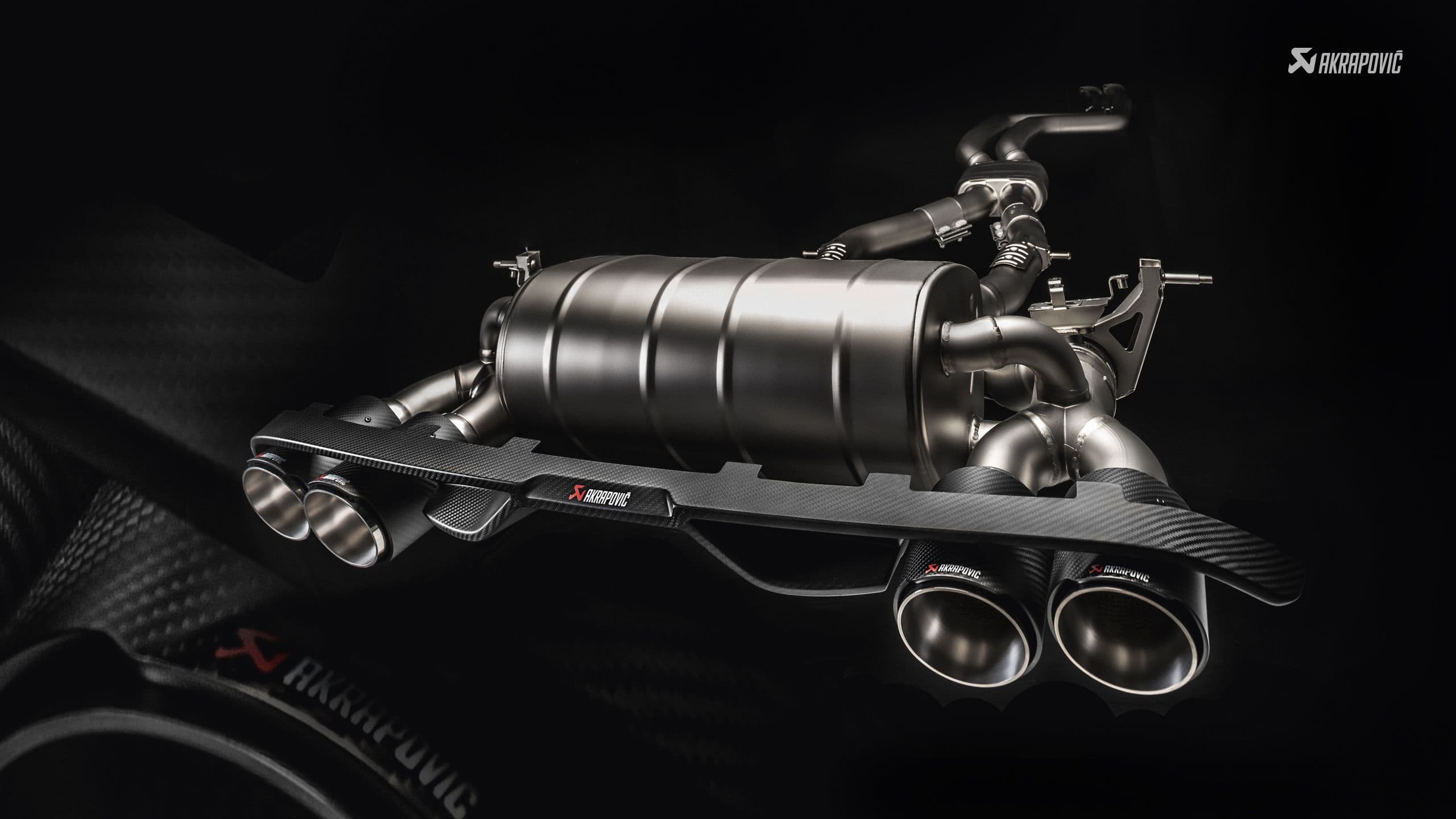 lähikuva ruostumattomasta teräksestä valmistetusta pakoputkesta mustalla pohjalla